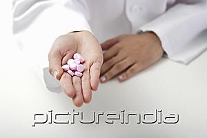 PictureIndia - Hand of doctor holding pills