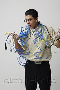 PictureIndia - Frustrated man with computer cords and wires