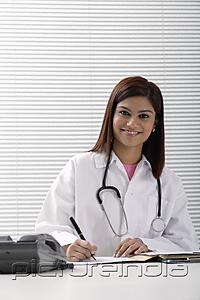 PictureIndia - Smiling doctor working with report