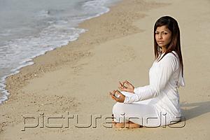 PictureIndia - woman practicing yoga at the beach