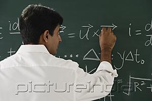 PictureIndia - teacher writing formulas on chalkboard