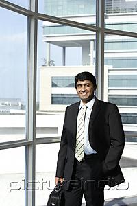 PictureIndia - business man holding briefcase, smiling