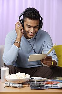 PictureIndia - young man listening to music with headphones on