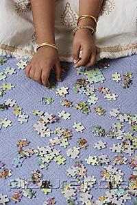 PictureIndia - Hands of little girl working on puzzle