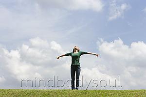 Mind Body Soul - Teen girl standing on grass, arms spread