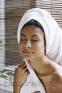 PictureIndia - Indian woman closing her eyes relaxing with towel on her head