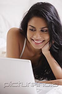 PictureIndia - Close up of Indian woman looking at laptop computer