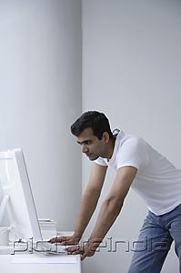 PictureIndia - Indian man looking at computer.
