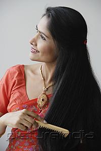 PictureIndia - Indian woman smiling while combing hair