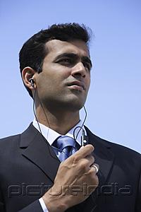 PictureIndia - Indian businessman using handsfree device.
