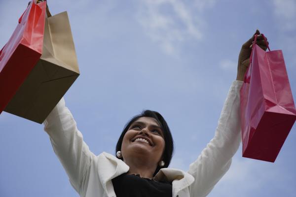 PictureIndia - Indian woman smiling and holding up shopping bags