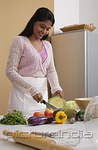 PictureIndia - Indian woman cutting vegetables in the kitchen