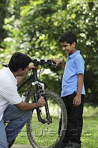 PictureIndia - Father and son fixing bike together