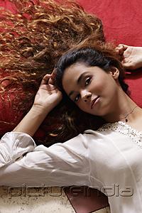PictureIndia - Young woman with long hair laying down