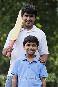 PictureIndia - Father holding cricket bat with son