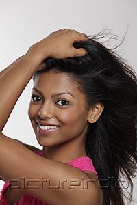 PictureIndia - head shot of smiling woman holding her hair