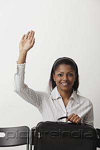 PictureIndia - Young woman raises her hand and smiles