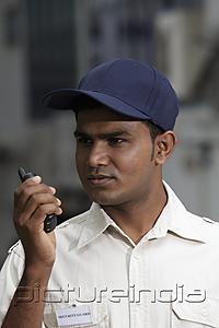 PictureIndia - Security guard talking into walkie talkie