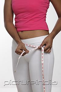 PictureIndia - Indian woman measuring her hips with tape measure