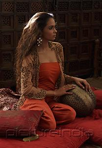 PictureIndia - Young woman relaxing on pillows with Indian antiques