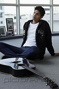 PictureIndia - young man sitting on floor with guitar