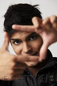 PictureIndia - head shot of young man making a frame with his fingers