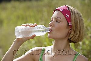 Mind Body Soul - young woman drinking from water bottle