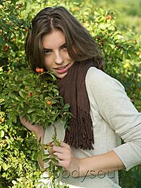 Mind Body Soul - Young woman holding branch of berry bush