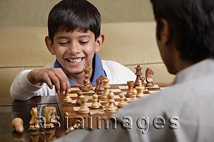 Asia Images Group - boy plays chess with father and smiles (horizontal)