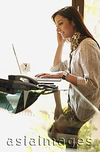 Asia Images Group - business woman working at laptop (profile)
