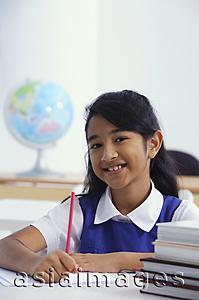 Asia Images Group - girl at desk with red pencil (vertical)