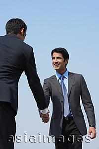 Asia Images Group - two businessmen shake hands (vertical)