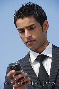 Asia Images Group - businessman checks his messages (vertical)
