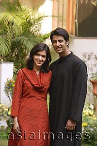 Asia Images Group - husband and wife standing for portrait in garden, smiling at camera