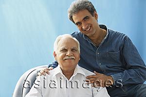 Asia Images Group - Senior man in chair, Adult son with hands on his shoulders