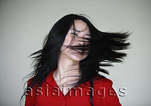 Asia Images Group - woman swinging her hair over her face
