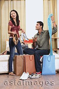 Asia Images Group - woman showing boyfriend shopping purchases