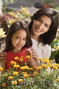 Asia Images Group - mother and daughter with flowers, smiling at camera