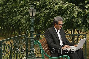 Asia Images Group - man with laptop on bench