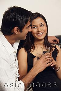 Asia Images Group - man and woman sitting closely with glasses of wine (vertical)