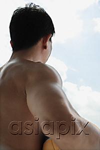 AsiaPix - Back view of muscular man holding ball