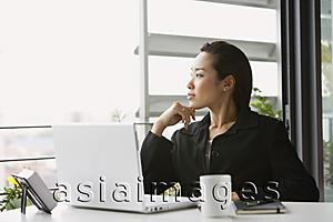 Asia Images Group - woman at desk, hand on chin