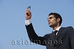 Asia Images Group - businessman checks his messages (horizontal)
