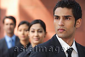 Asia Images Group - businessman in foreground, three colleagues in background
