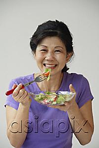 AsiaPix - Woman eating green salad