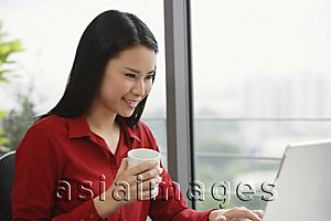 Asia Images Group - woman with coffee at laptop