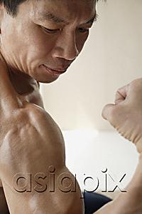 AsiaPix - Profile of man flexing muscles