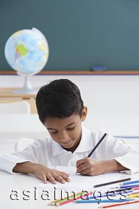 Asia Images Group - boy at desk with colored pencils