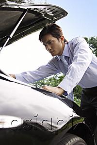 AsiaPix - Businessman looking under hood of car