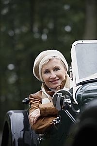 Mind Body Soul - Senior woman leaning over side of antique car